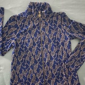 Lilly Pulitzer Blue Bomber Jacket with High Collar and Intricate Gold Pattern.